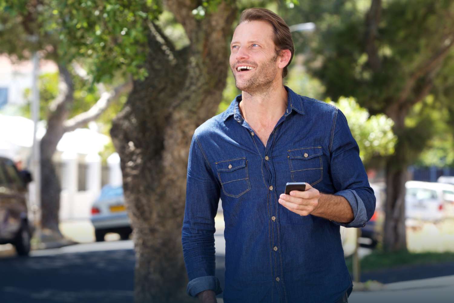 Mobile phone user outdoors, symbolizing consistent wireless coverage and customer experience