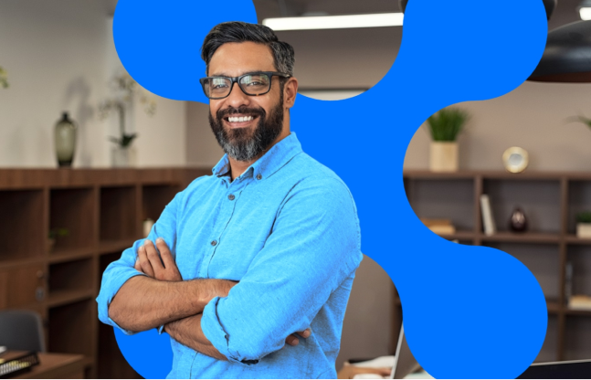 Smiling subscription business owner standing with arms crossed in a contemporary office