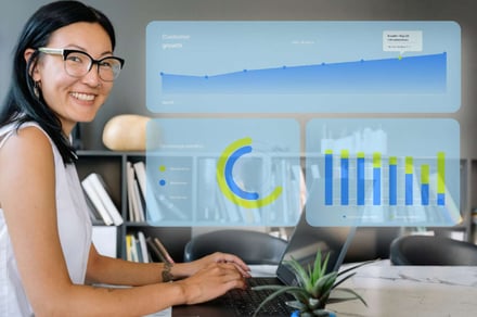Smiling product woman working on a laptop with transparent dashboards overlaid